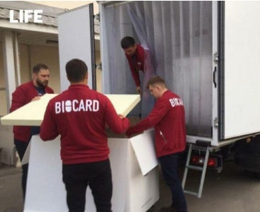 Сотрудники Biocard грузят бокс в рефрижератор. Biocard - перевозки термозависимых грузов с температурным режимом по РФ 